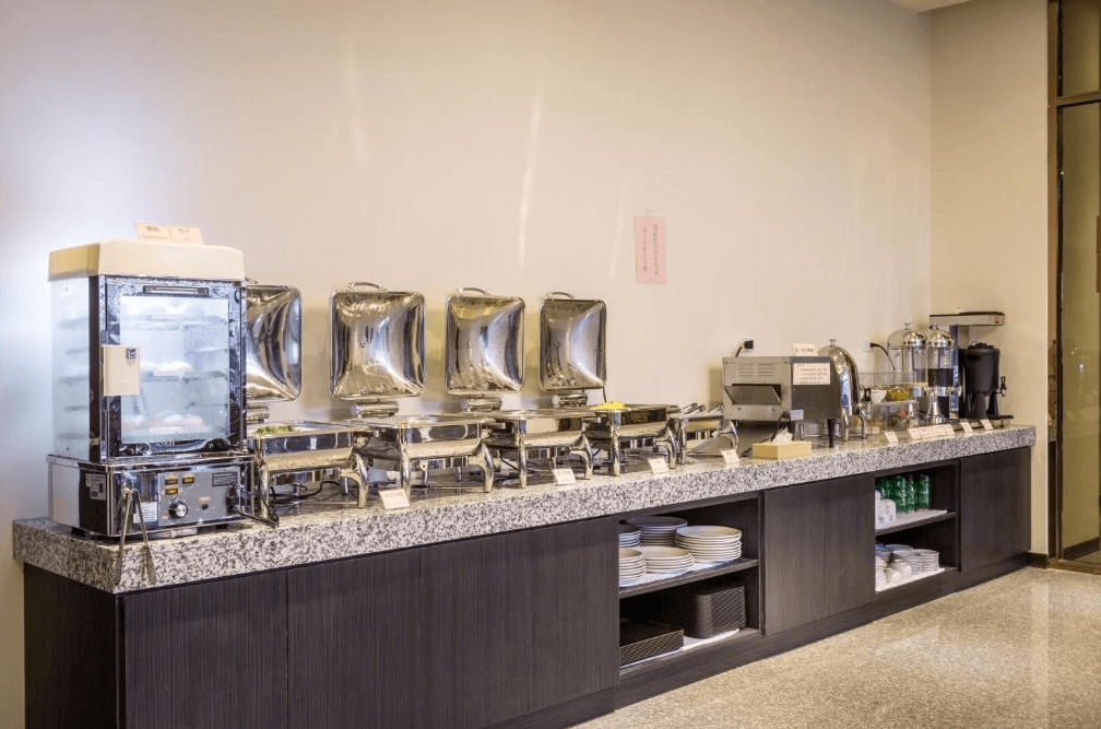 【西螺住宿】米都商務飯店早餐自助餐檯，設有多個不鏽鋼保溫餐爐與飲料區，提供多樣化的中西式早餐選擇。