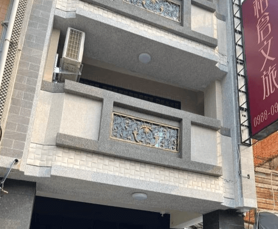 【西螺住宿】粨倉文旅外觀，灰白色系現代化建築，陽台設有金屬雕花欄杆，外牆設計精緻，整棟民宿外觀典雅大方。