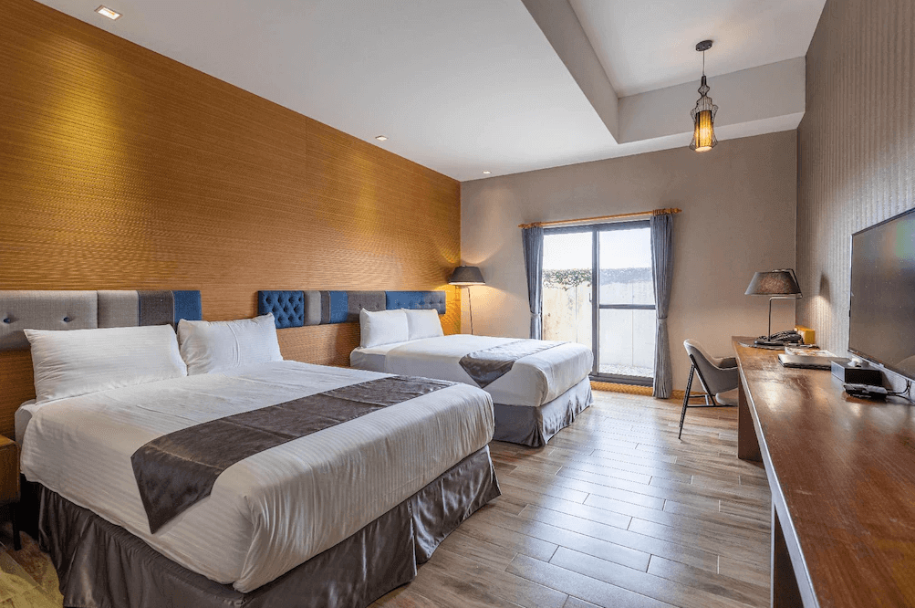 【花蓮寵物友善飯店】統茂渡假莊園雙床客房，配有兩張大床與木地板設計，大片窗戶採光良好，整體風格簡約現代，空間寬敞舒適，適合家庭或好友入住。