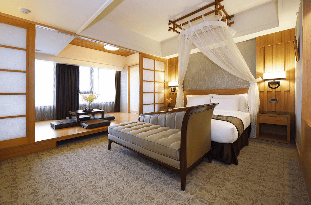 【花蓮寵物友善飯店】花蓮福容大飯店和洋風格客房，設有一張大床與榻榻米區，搭配紗帳裝飾與木質屏風，空間寬敞典雅，展現東方禪意與現代舒適完美融合。