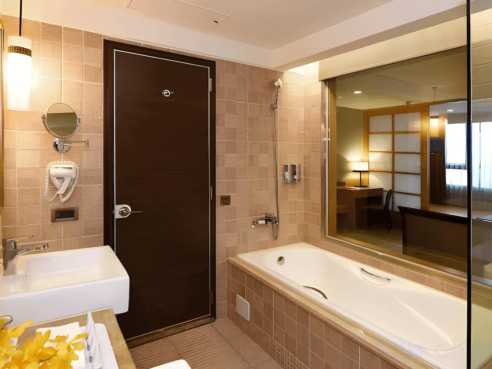 【花蓮寵物友善飯店】花蓮福容大飯店浴室設施，擁有獨立浴缸與乾濕分離空間，大片透明玻璃可望向臥室區，牆面採米色磁磚設計，整體舒適寬敞。