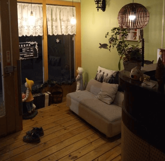 【西螺住宿】西螺後街童畫民宿溫馨大廳，木地板搭配柔黃燈光與布偶擺飾，營造出童話般的溫暖迎賓氛圍。