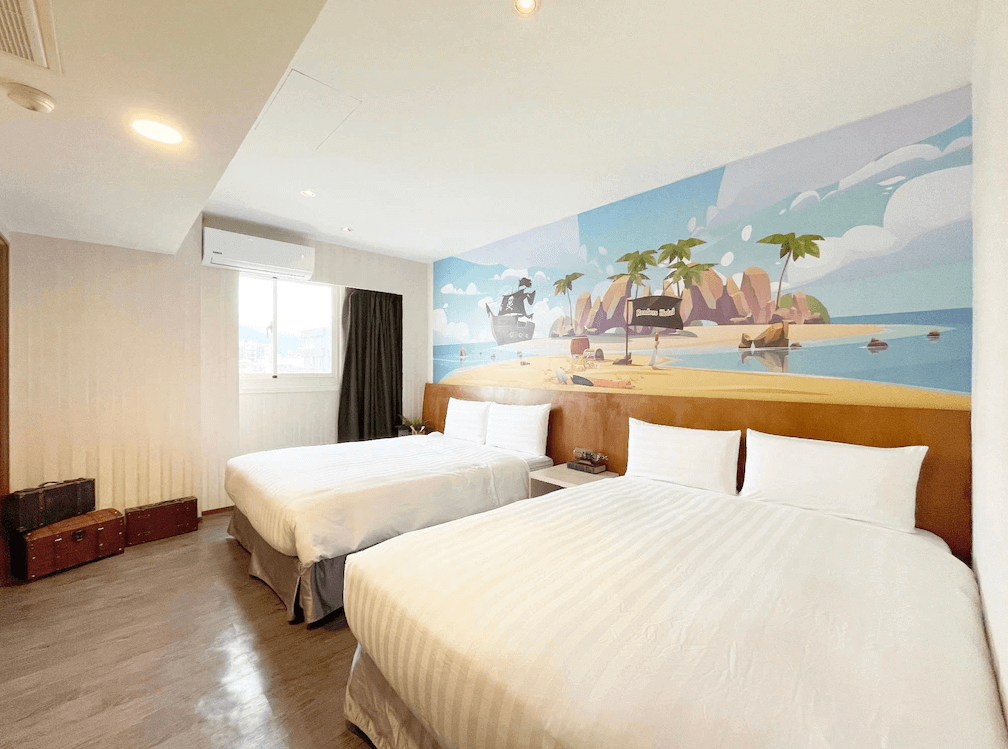 【花蓮寵物友善飯店】路徒行旅 花蓮東大館主題家庭房，牆上彩繪熱帶島嶼與海盜船卡通風景，房內設有兩張雙人床與明亮自然採光，充滿童趣與度假氛圍。