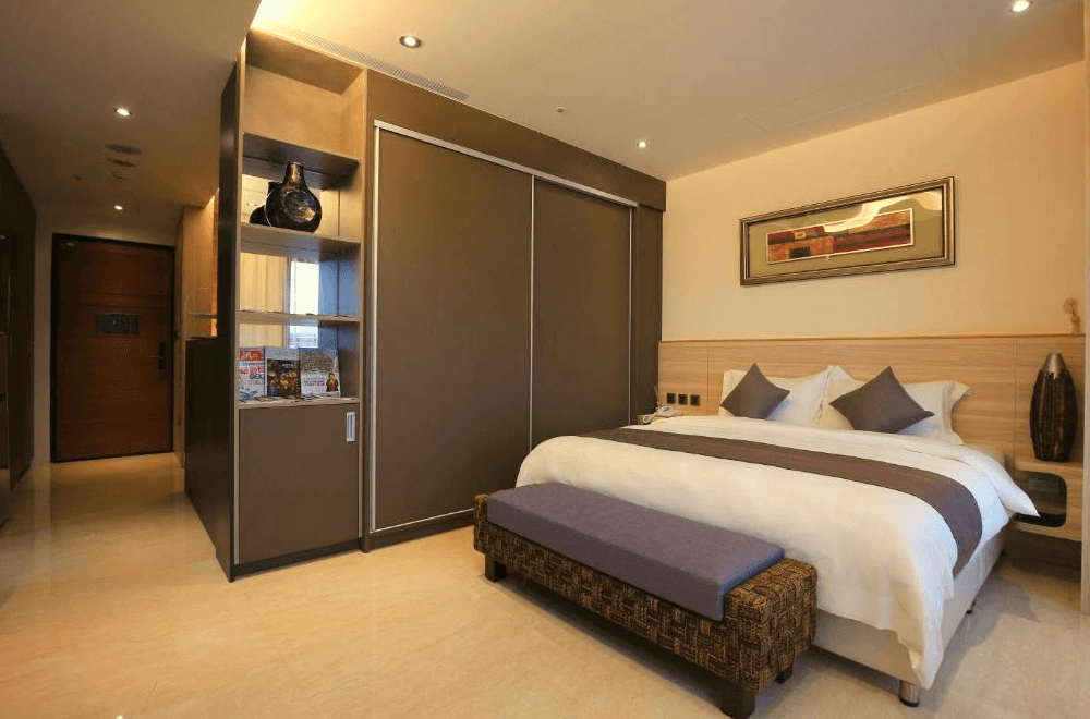 【新竹東區住宿】達龍商旅舒適雙人房，設計簡約典雅，配有紫色長凳與內嵌式衣櫃，空間整潔實用。