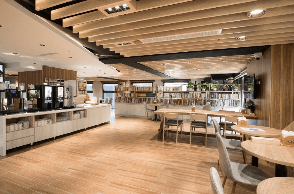 【新竹東區住宿】達龍商旅早餐餐廳，空間明亮寬敞，採木質設計風格並設有大量書籍陳列，提供咖啡機與多樣自助餐選擇。