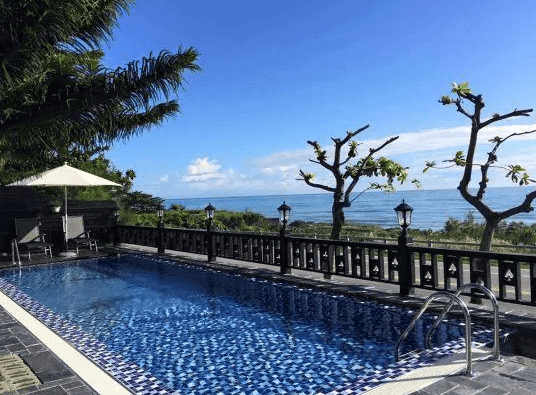 【花蓮寵物友善飯店】都鐸王朝戶外泳池區，坐擁絕美太平洋海景，泳池旁設有休憩陽傘與躺椅，適合旅客放鬆賞景，享受陽光與藍天的假期時光。