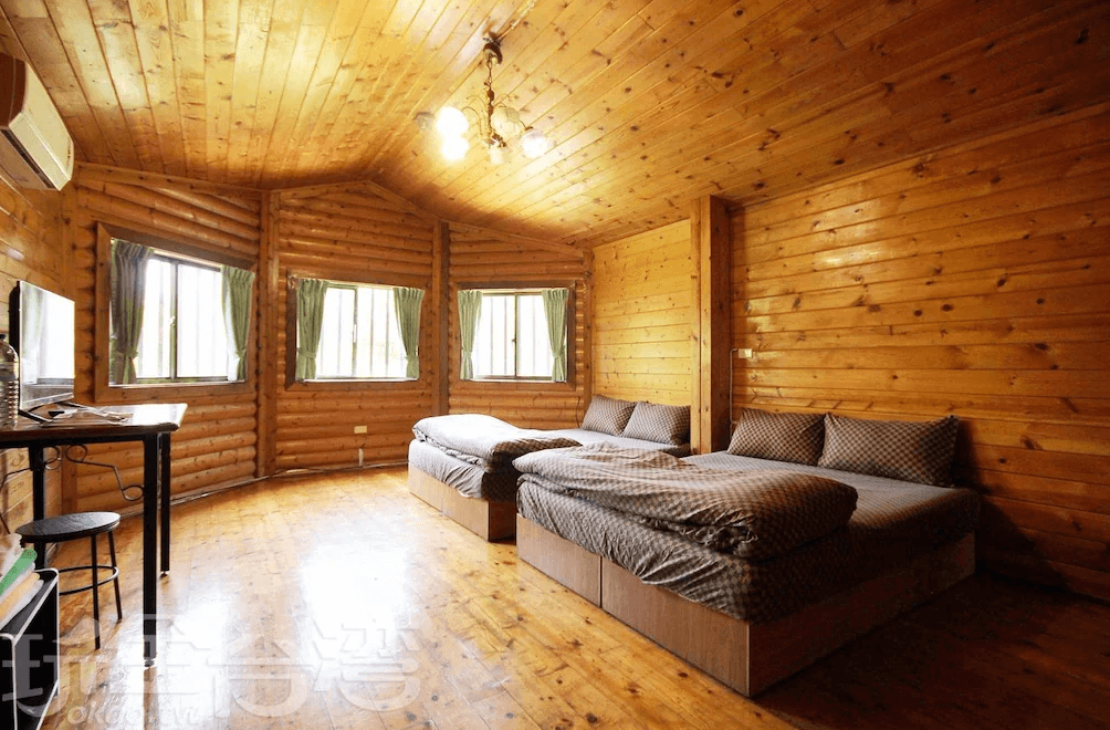 【竹山住宿】雙湖渡假山莊木屋雙人床房型，室內全為溫暖木質調設計，空間寬敞明亮，擁有多面窗戶與大片自然採光，提供兩張雙人床，適合親子或好友同行入住。