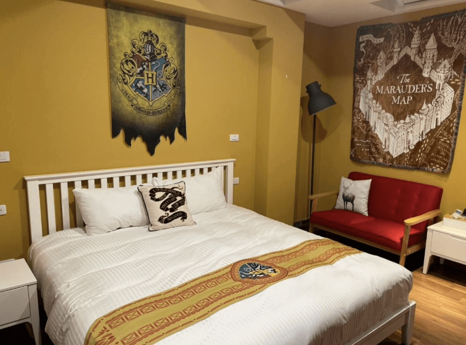 【清水住宿】鹿莫思 LUMOS 哈利波特主題房，牆面掛有霍格華茲徽章與活點地圖掛布，搭配白色床架與葛來分多風格配件。