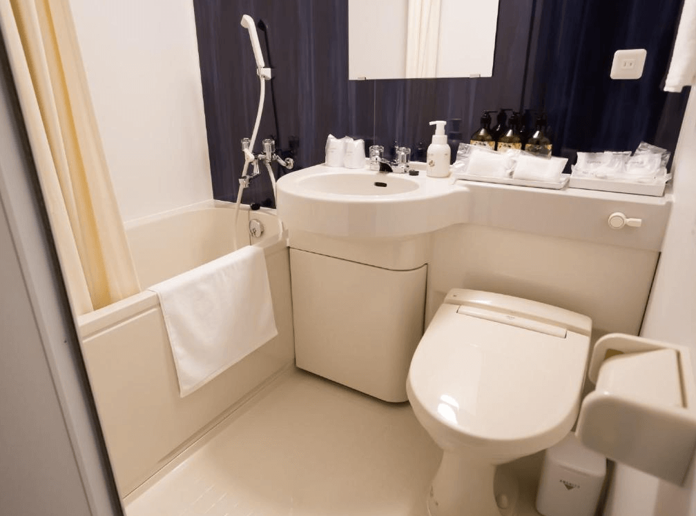 【名護住宿】Hotel Peace Island Nago 浴室，配有浴缸、免治馬桶與洗手台，設施整潔，並提供盥洗用品與毛巾。