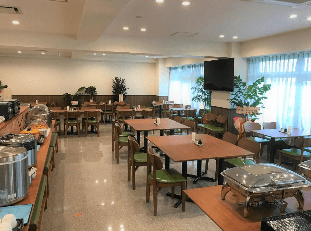 【名護住宿】Hotel Peace Island Nago 餐廳，明亮寬敞的用餐空間，擺放多張餐桌與自助餐台，供應早餐與多樣化餐點。