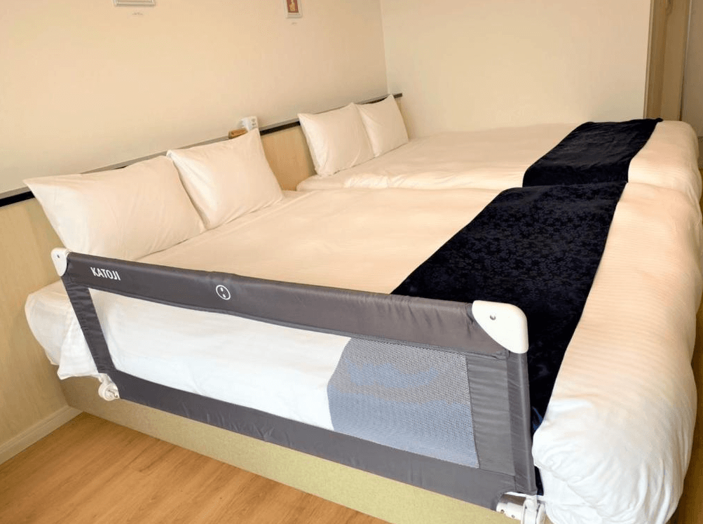 【名護住宿】Hotel Sakurano Familia Nago 家庭房，兩張大床合併並設有嬰幼兒安全床圍，適合親子入住，提供溫馨舒適的住宿體驗。