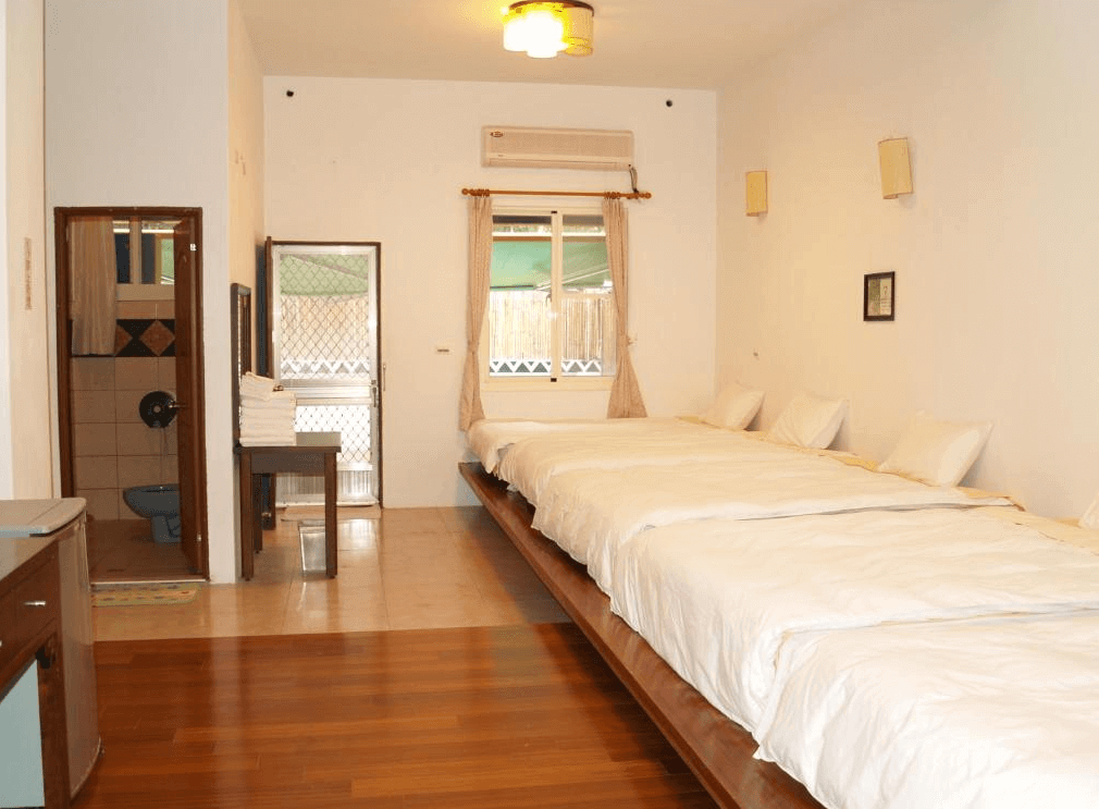 【金崙住宿】"太麻里住宿"丹堤溫泉會館四人房型，室內設有木質地板與整排並列床鋪，簡潔乾淨，附設衛浴與窗外自然採光。