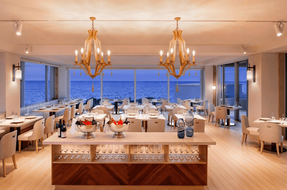 【宮古島住宿】伊良部島翠豪華精選酒店的海景餐廳設計典雅，大片玻璃窗將海平線盡收眼底，搭配浪漫吊燈與高級餐酒，營造極致用餐體驗。