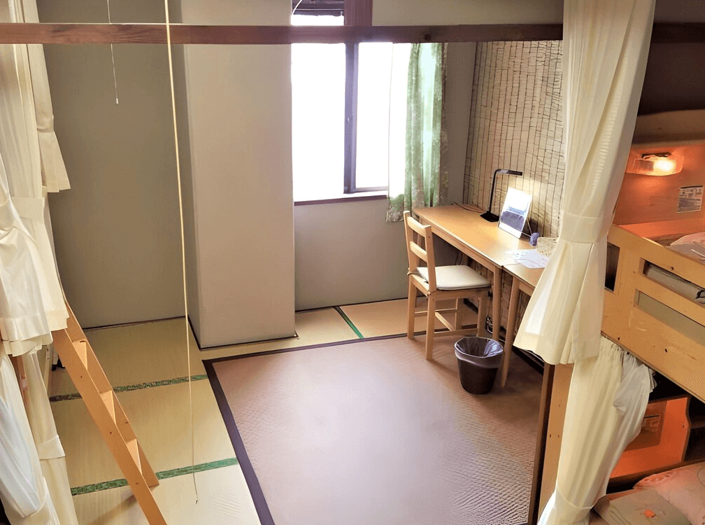 【名護住宿】全友民宿 (All Friends Guest House) 多人合住房，木製上下舖設計，旁邊有書桌、椅子與閱讀燈，搭配榻榻米地板，適合長住與學習。