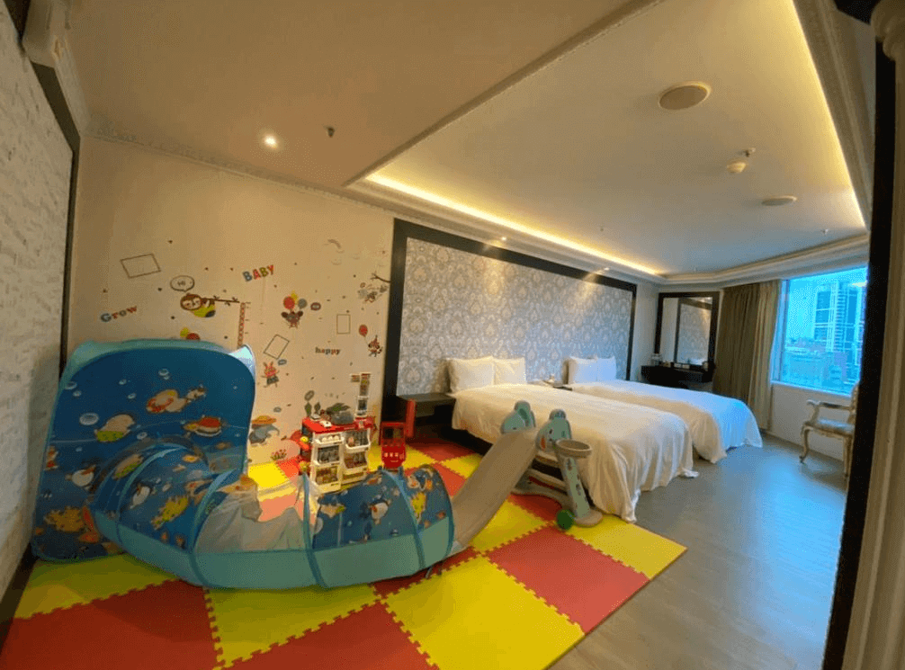 【板橋住宿】友愛金色商旅 浴室空間，設有浴缸、洗手台與馬桶，牆面帶有卡通貼紙裝飾，營造輕鬆氛圍。