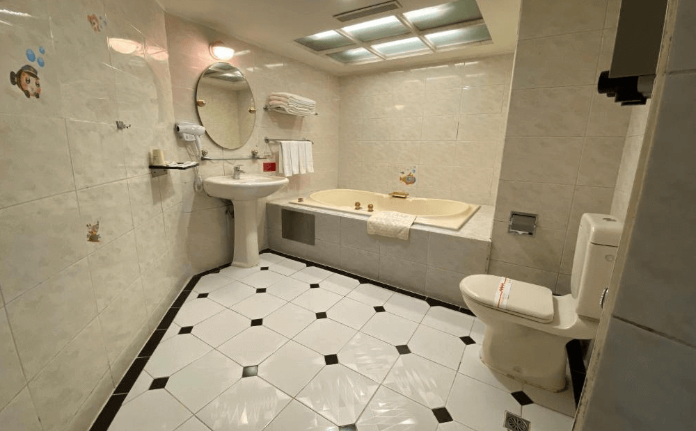 【板橋住宿】友愛金色商旅 親子房，房內配有兒童遊戲設備、溜滑梯與彩色遊戲墊，牆面裝飾童趣圖案，適合親子家庭入住。