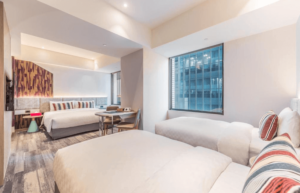 【板橋住宿】台北趣淘漫旅 家庭房配置一張大床與兩張單人床，採用明亮現代風格設計，窗邊採光良好，適合親子或多人入住。