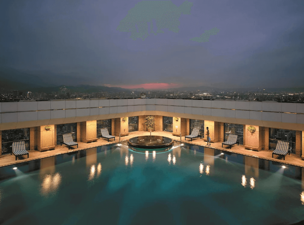 【大安住宿】台北遠東香格里拉戶外泳池 —— 頂樓泳池夜景，四周設有躺椅與迴廊，能俯瞰台北城市燈火，氛圍高雅浪漫。