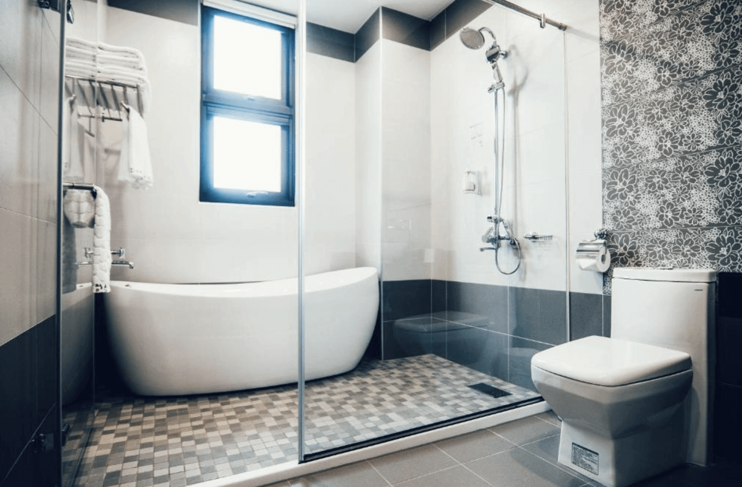 【吉安住宿】哉煙煙民宿浴室，配有獨立浴缸與乾溼分離淋浴間，牆面局部採用花卉磁磚設計，空間寬敞明亮。