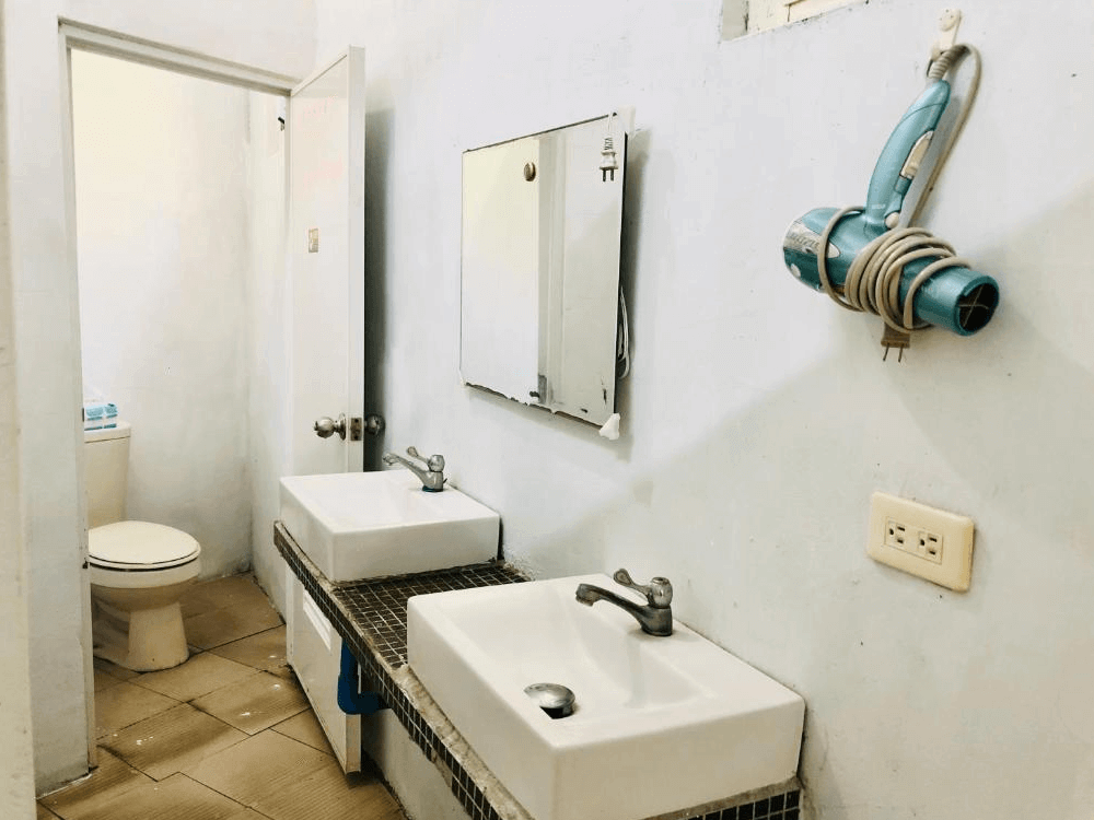 【蘭嶼住宿】嘟嘟悟的家共用衛浴：設有兩個洗手台、大鏡子與吹風機，旁邊連接獨立廁所與淋浴間，提供實用便利的設施。
