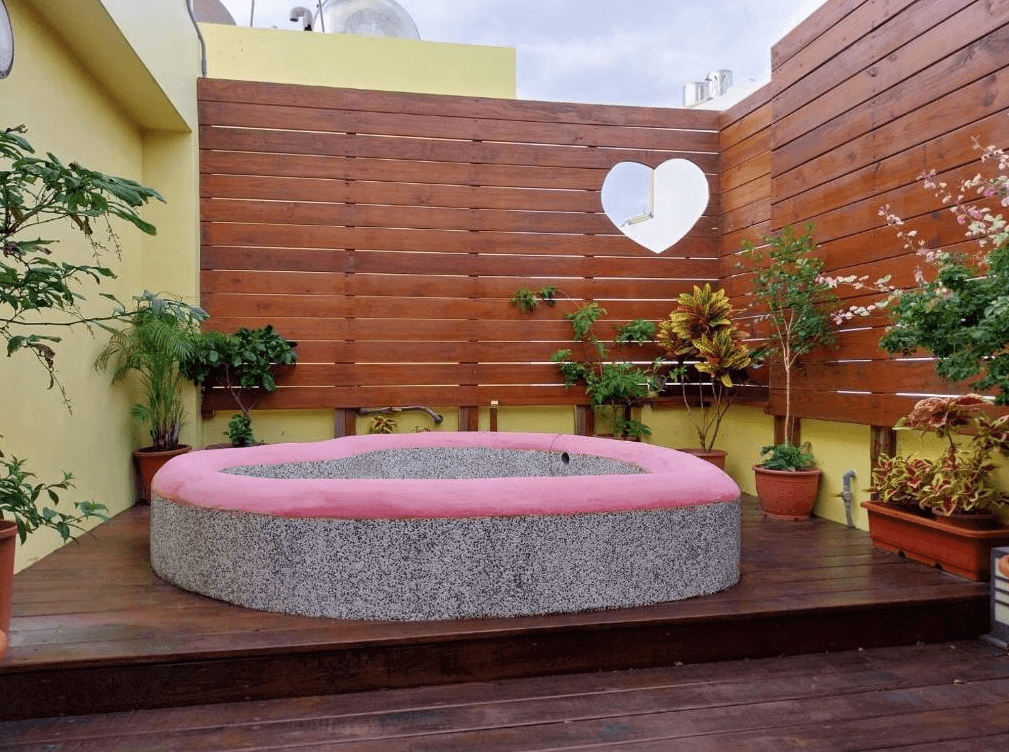 【墾丁寵物友善住宿】墾丁巴里巴里戶外泡湯區 — 露天空間設有粉色心形邊框的石造泡湯池，周圍以木板與綠植點綴，營造浪漫私密氛圍。