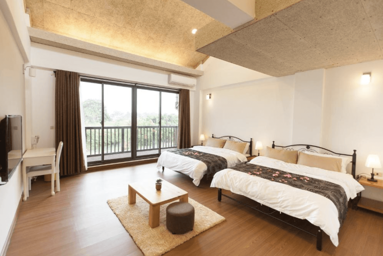 【吉安住宿】夏洛克Villa民宿 景觀四人房 — 寬敞明亮空間搭配兩張大床，木質地板與溫暖燈光營造舒適氛圍，設有觀景陽台可欣賞戶外綠意。