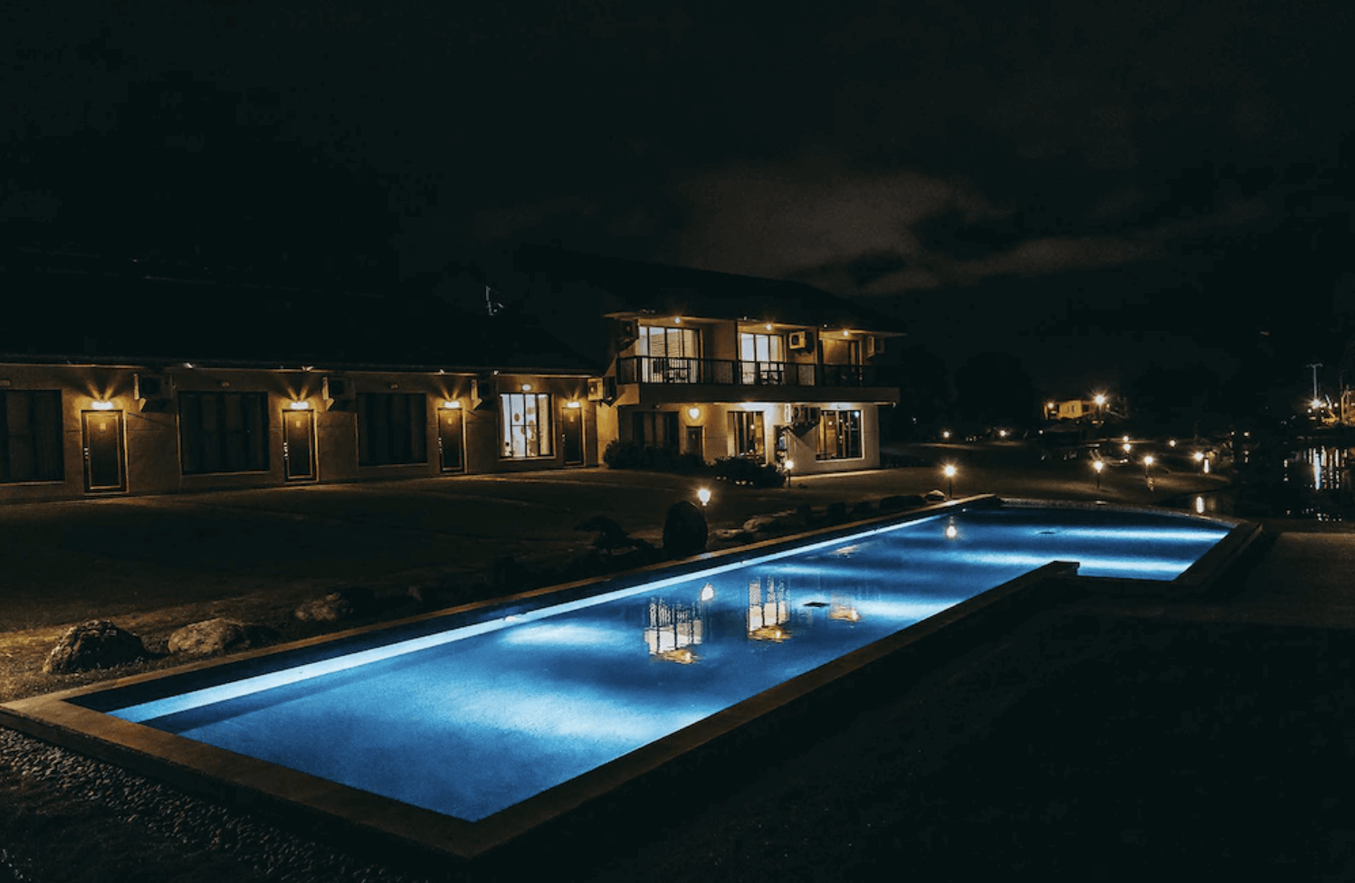 【吉安住宿】夏洛克Villa民宿 夜間泳池景觀 — 夜色下的長形泳池燈光映照水面，民宿建築與周圍燈光交織出靜謐度假氛圍。