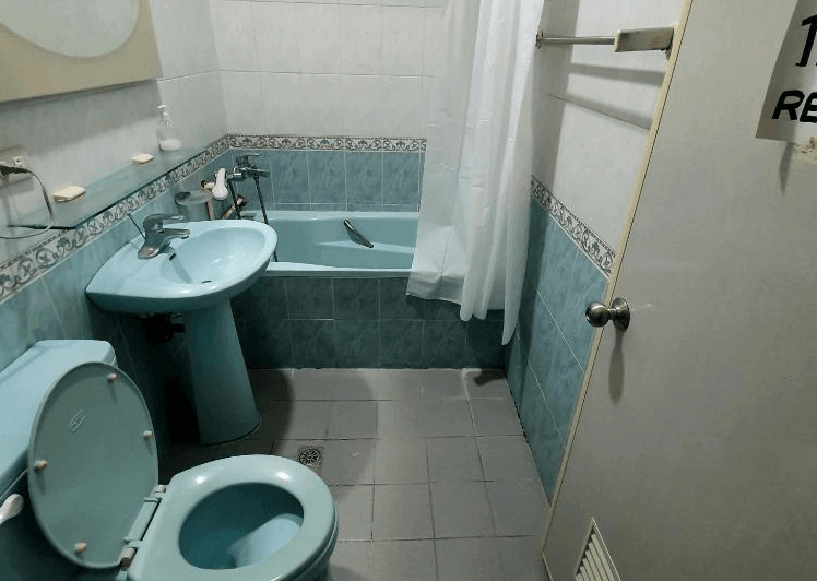 【太麻里住宿】太麻里左奶奶的家浴室，藍綠色衛浴設備搭配浴缸，設有洗手台、馬桶與淋浴空間，充滿復古感。