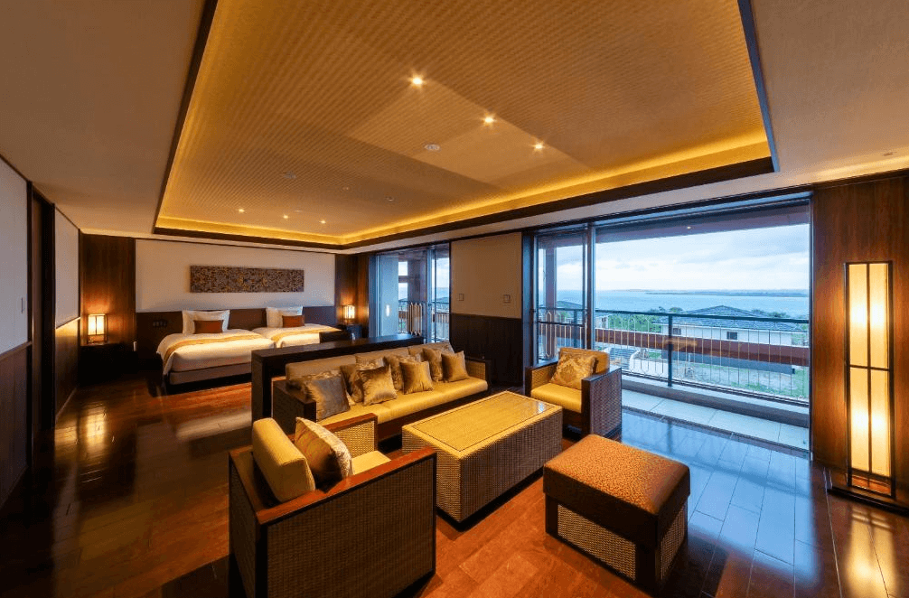 【宮古島住宿】宮古島來間度假村海木飯店的和風海景套房，融合木質地板與溫暖燈光設計，設有舒適客廳與大片落地窗，夜晚可欣賞靜謐海景與自然景色。