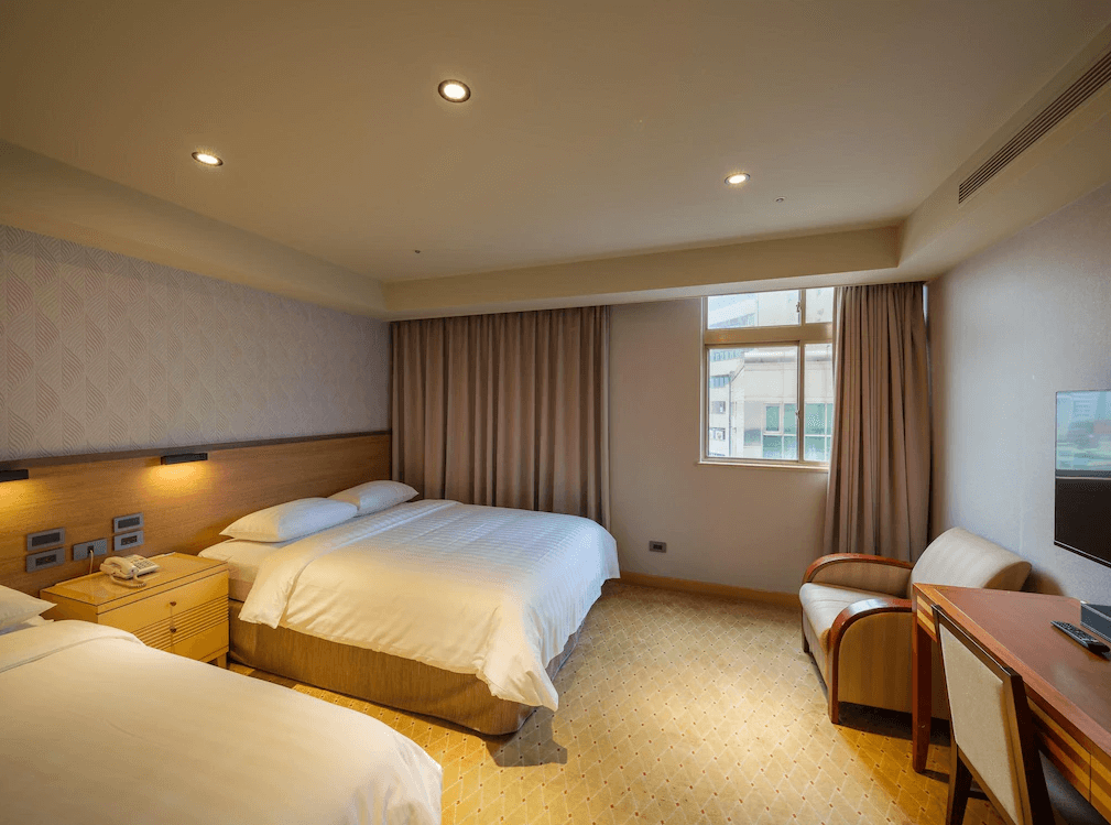 【板橋住宿】富逸旅趣-板橋府中館 標準雙床房 – 現代簡約設計的雙人床房型，木質家具與溫暖燈光營造舒適氛圍，窗戶採光良好，設有書桌與座椅。