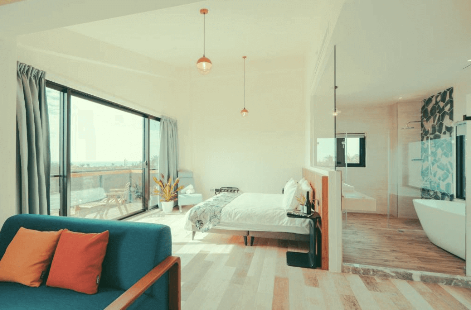 【恆春住宿】《墾丁白砂15 Villa民宿》寬敞套房空間，擁有大片落地窗、獨立浴缸與乾濕分離衛浴設計，房內另備有休憩沙發與植栽，打造度假感十足的放鬆環境。