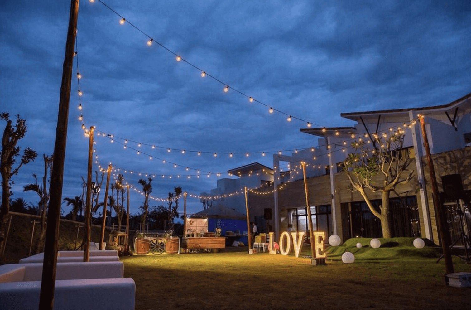 【恆春住宿】嵐翎白砂渡假莊園戶外草地夜景，串燈高掛、LOVE字樣燈飾閃耀，現場布置如婚禮場景般浪漫溫馨，適合舉辦戶外派對或活動。