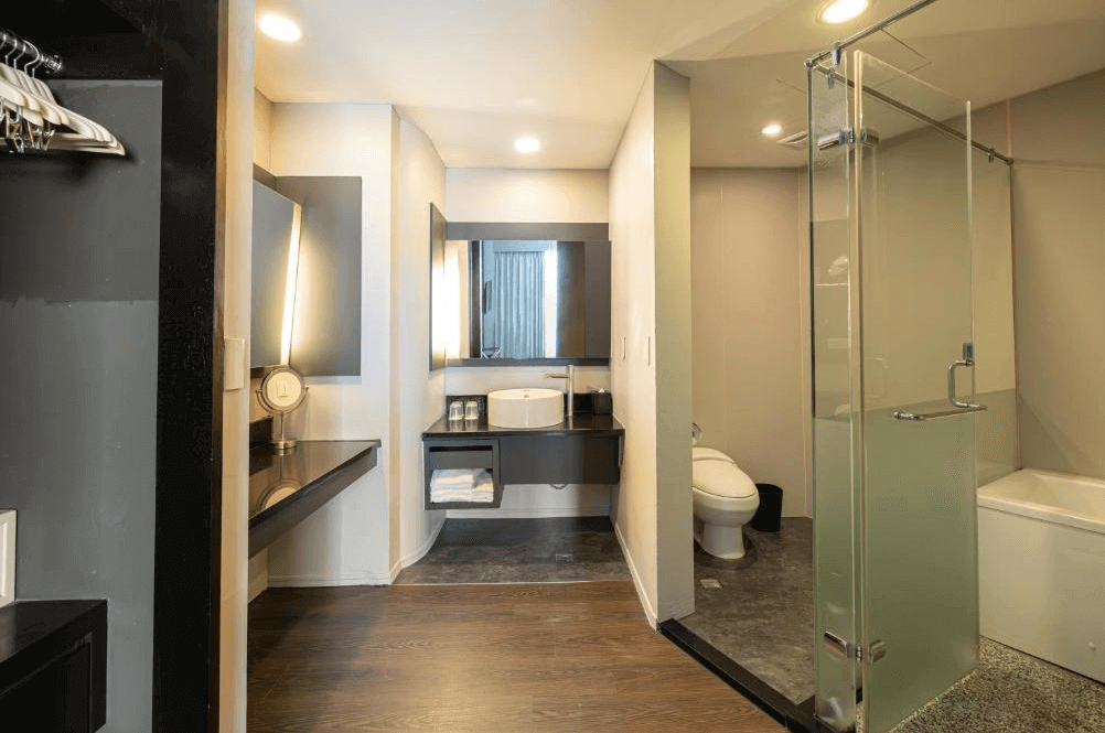 【大安住宿】捷絲旅 臺大尊賢館浴室空間 —— 現代化設計，乾濕分離，配有玻璃淋浴間、浴缸與大型化妝鏡，空間明亮整潔。