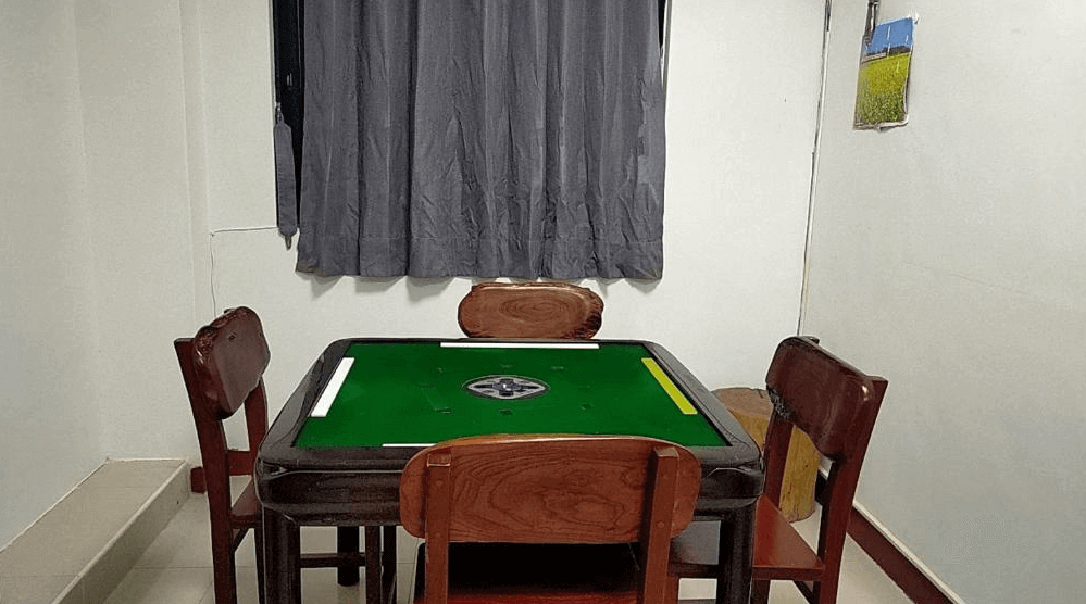 【金崙住宿】"太麻里住宿"東金民宿麻將娛樂室，配有全自動麻將桌與四張木椅，提供房客休閒娛樂選擇。