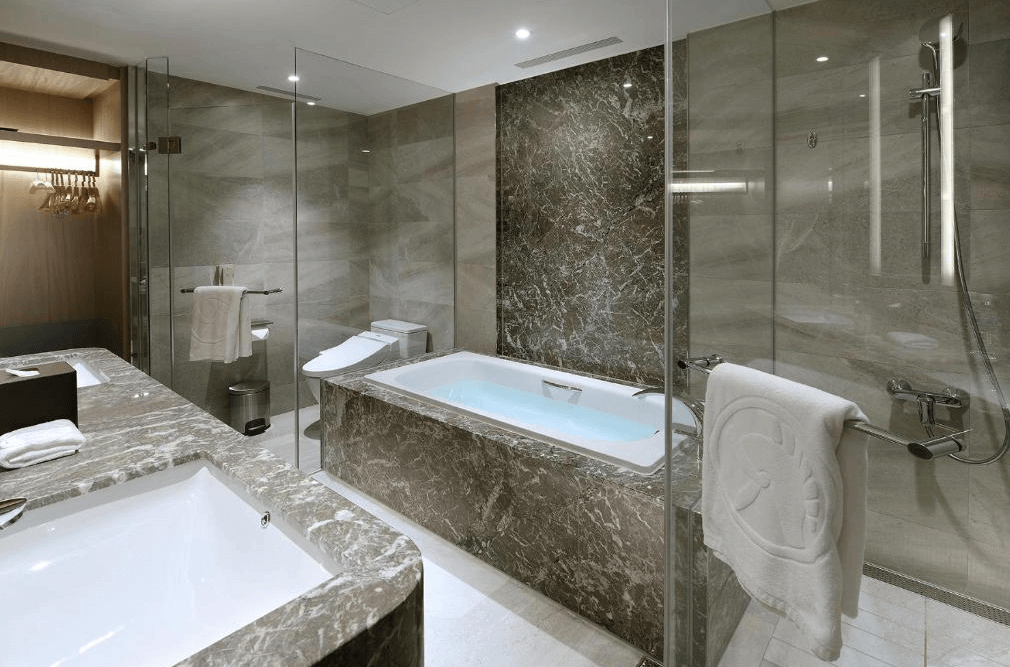 【板橋住宿】板橋凱撒大飯店 浴室空間，配有大理石雙洗手台、獨立淋浴間與泡澡浴缸，設計寬敞明亮。