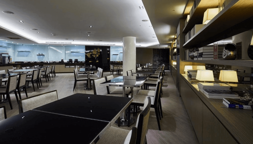 【大安住宿】柯達大飯店台北敦南餐廳 —— 典雅設計的餐廳空間，黑色餐桌與米色座椅搭配，提供自助餐與多樣化餐點，氛圍安靜舒適。