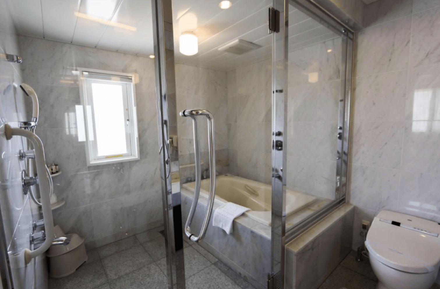 【那霸住宿】棕櫚皇家度假飯店國際通餐廳 — 寬敞明亮的用餐空間，木質桌椅整齊排列，窗外透入自然光。