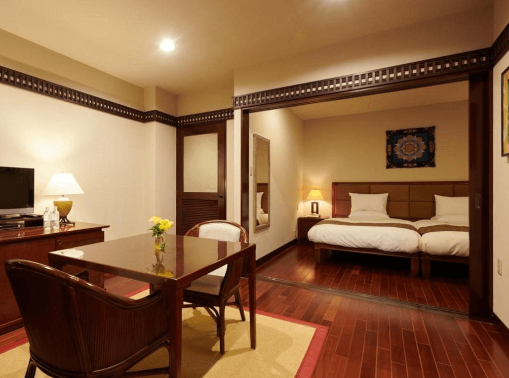 【宮古島住宿】汐姬繁花海灣套房飯店的雙人套房，融合和洋風格設計，設有木質地板、獨立臥室與餐桌區，空間溫馨舒適，適合情侶或小家庭入住。