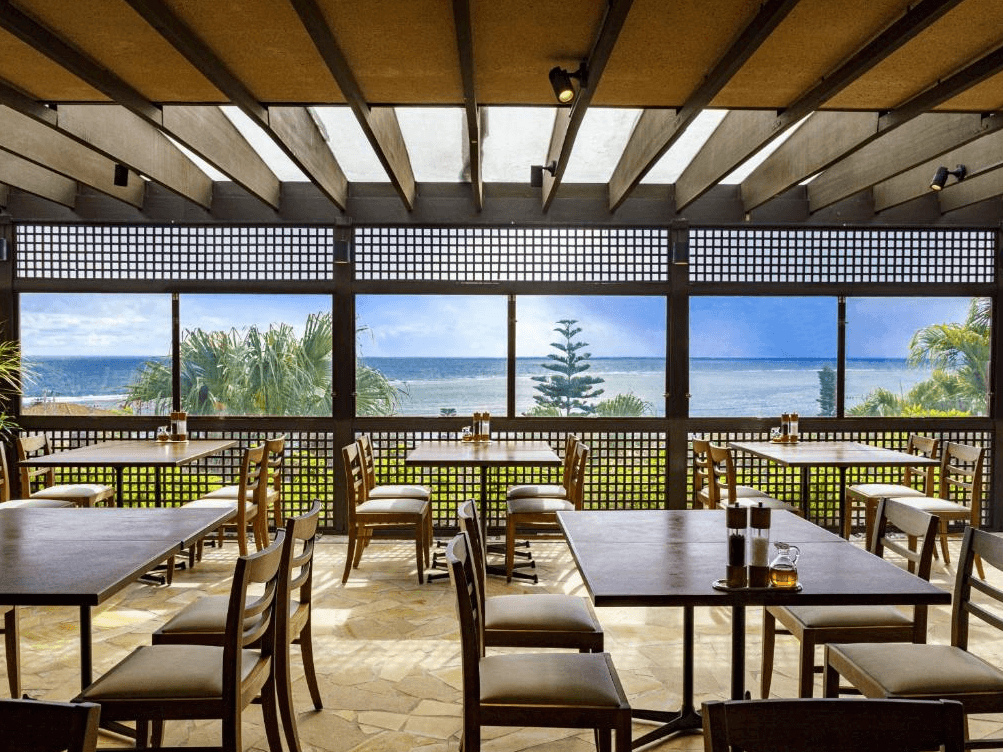 【宮古島住宿】汐姬繁花海灣套房飯店的海景餐廳，擁有大片窗景可欣賞蔚藍大海與綠意景致，提供愜意用餐氛圍與絕佳景觀。