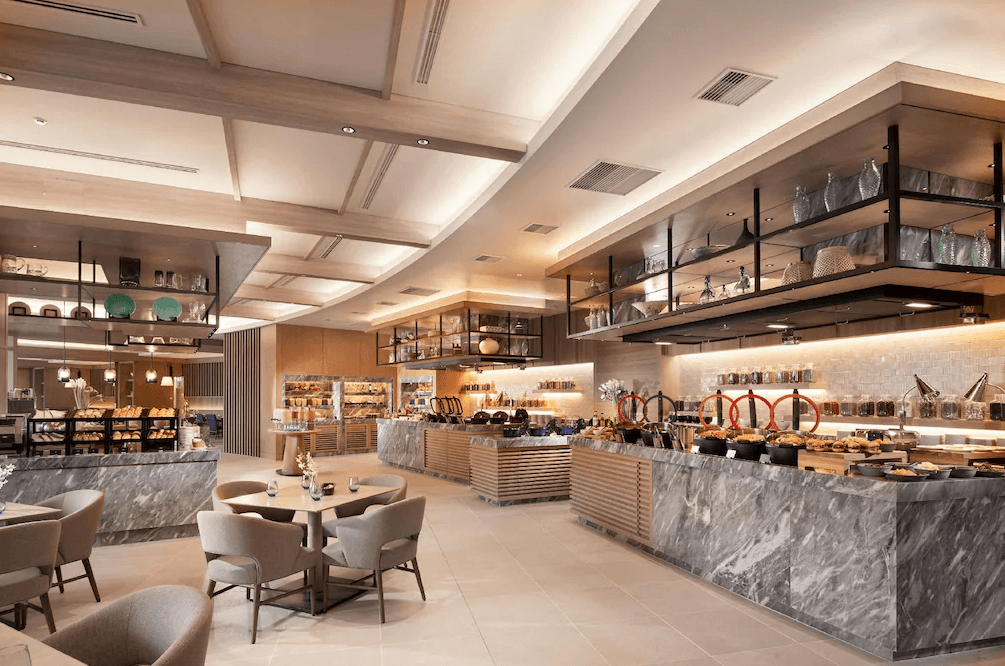 【宮古島住宿】沖繩宮古島希爾頓度假酒店內部餐廳，設計時尚高雅，自助吧台提供豐盛多樣的料理選擇，搭配舒適座位區，是享用早餐與午餐的理想場所。