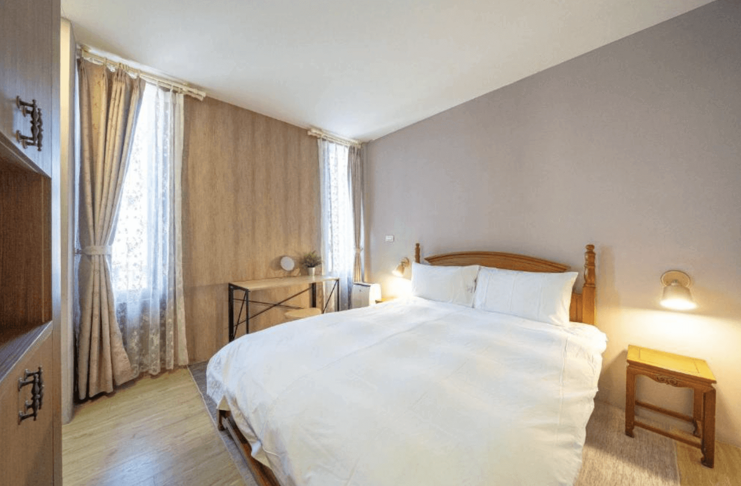 【吉安住宿】海邊很近民宿溫馨雙人房，木質地板搭配淺色牆面，擺放雙人床、床頭櫃與書桌，兩側有大面窗戶採光明亮。