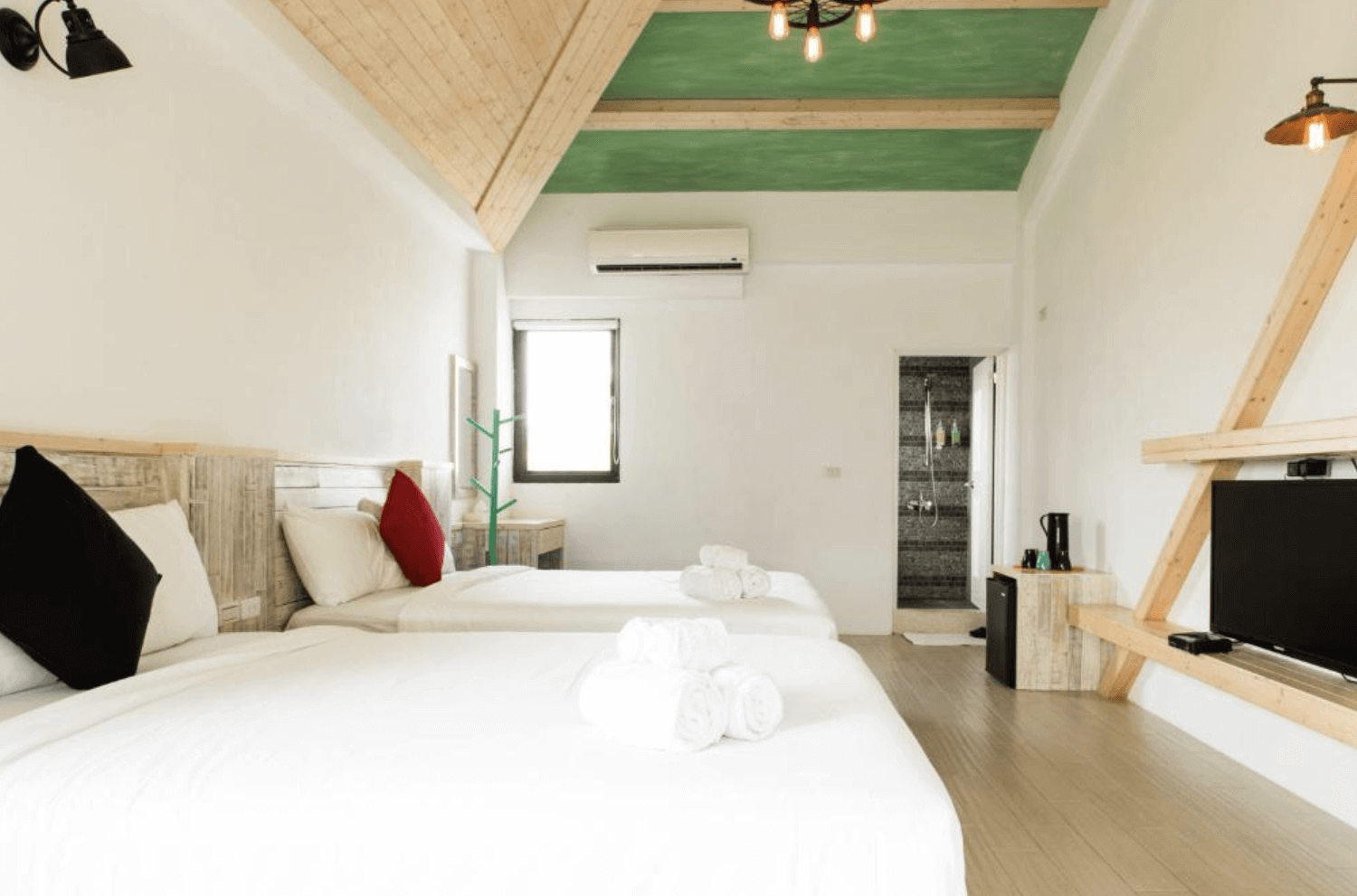 【恆春住宿】燕麥小別館房型｜三人房設計感十足，挑高木質斜屋頂配綠色天花板，房內設有平面電視與木作裝飾，簡約又溫馨。