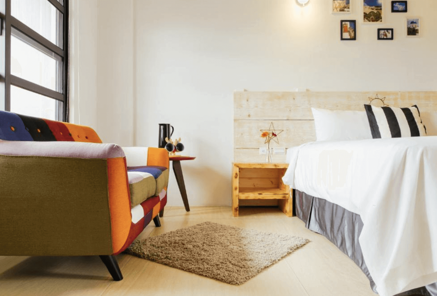 【恆春住宿】燕麥小別館房型｜色彩繽紛的單人沙發與溫暖木質床頭櫃，搭配簡約佈置與自然光，營造舒適明亮的空間。