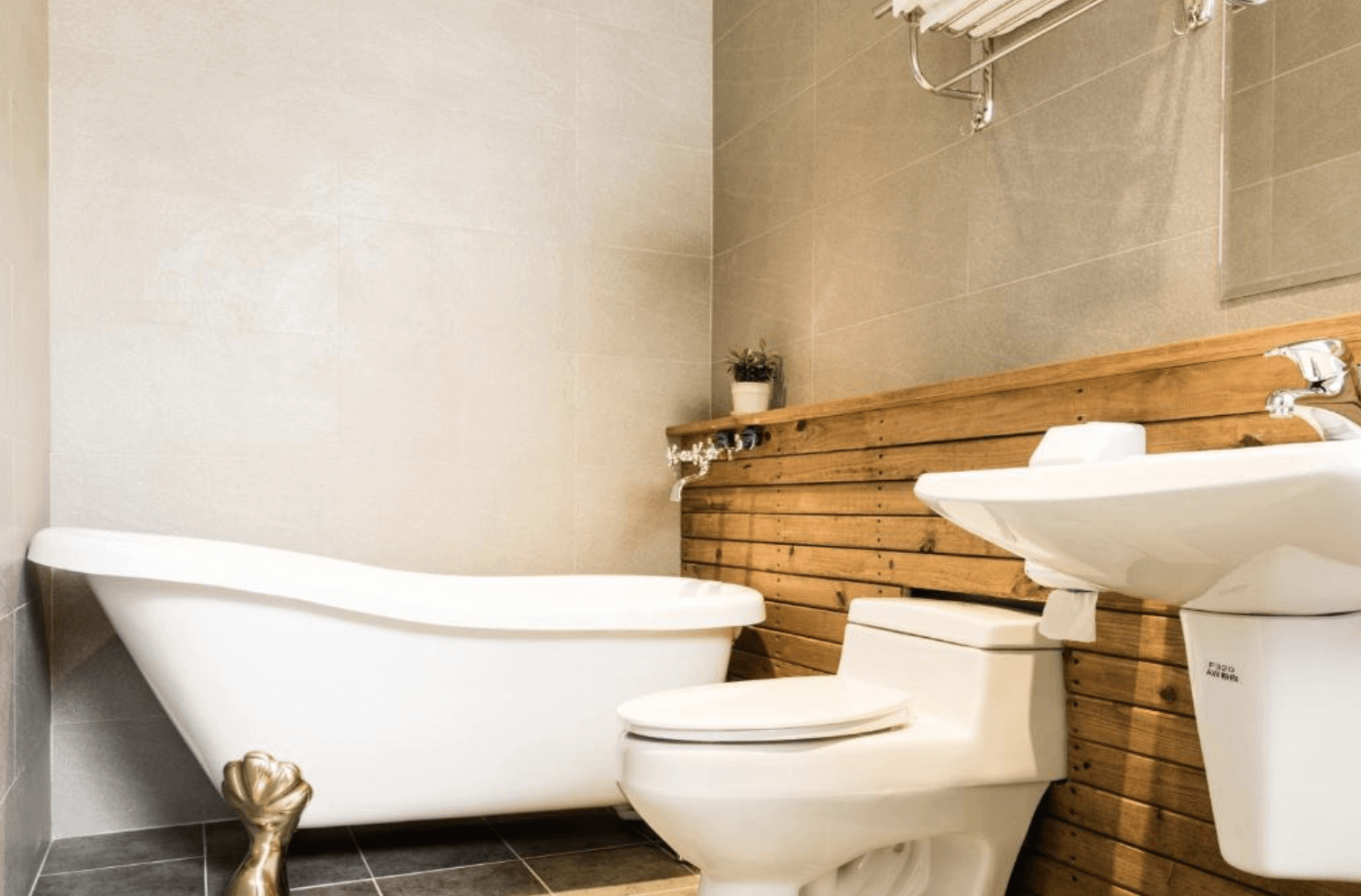 【恆春住宿】燕麥小別館浴室｜設有復古獨立式浴缸與木紋牆面設計，搭配現代洗手台與馬桶，融合懷舊與現代風格。