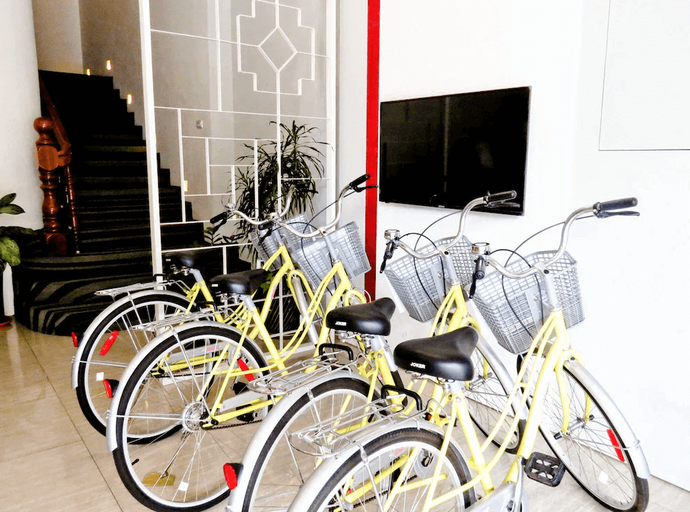【太麻里住宿】狀元樓商務旅店大廳提供免費腳踏車租借服務，數輛黃色自行車整齊停放在白色空間內。