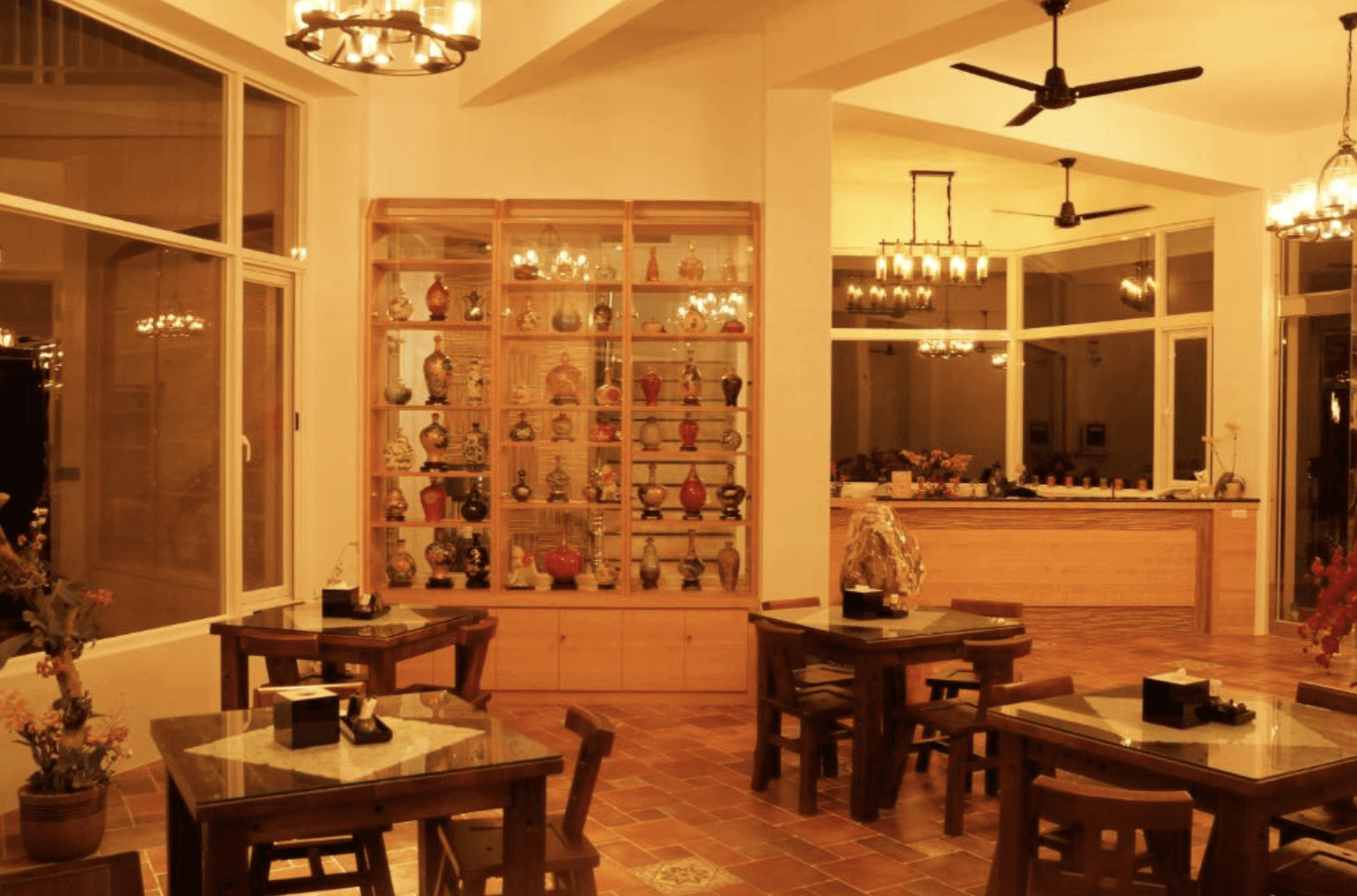 【恆春住宿】珊瑚園民宿大廳空間，充滿溫馨氛圍與古典韻味，展示多樣陶瓷藝術收藏，搭配溫暖黃光與木質桌椅，是享用早餐與午後茶的理想場域。