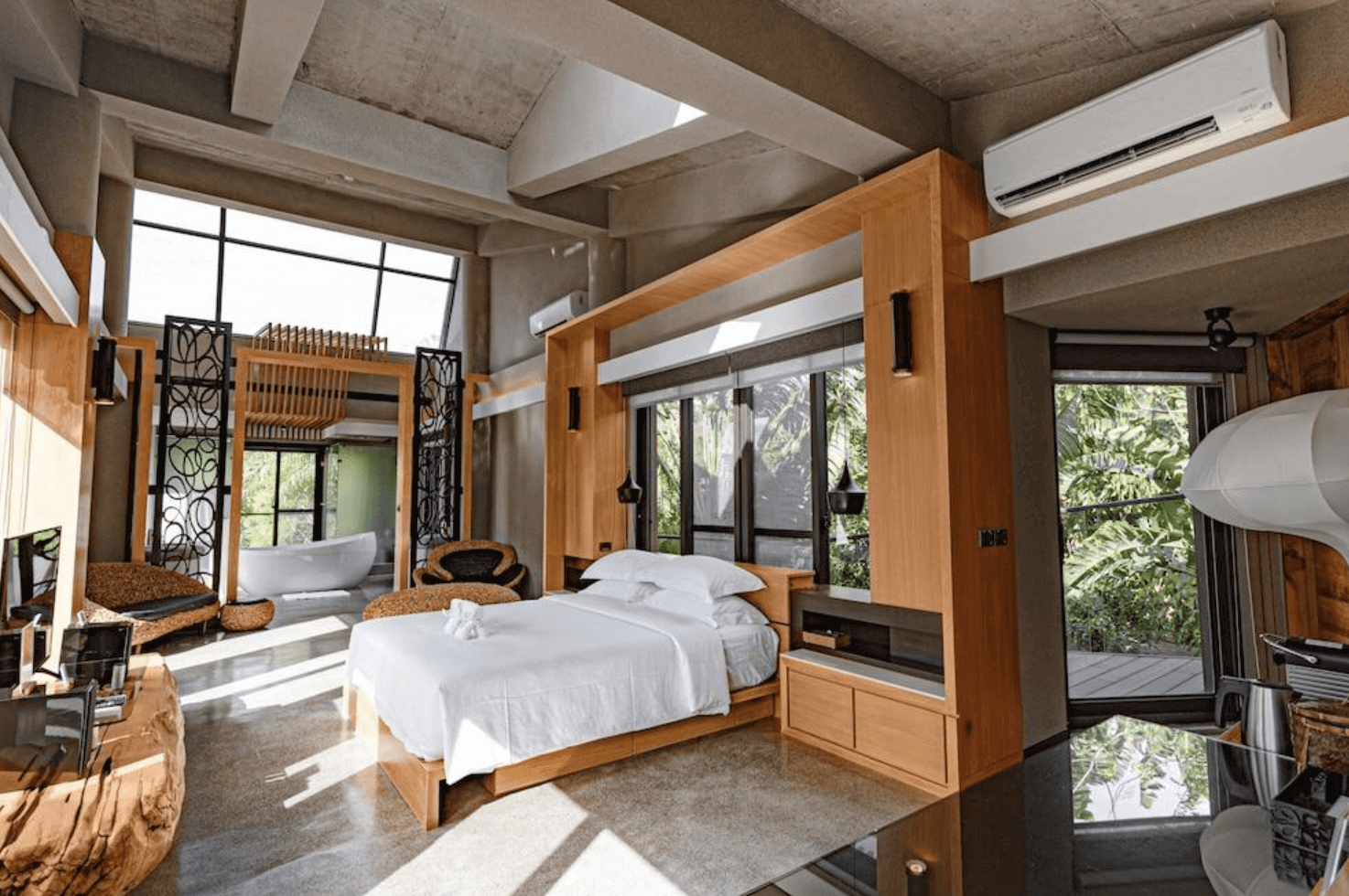 【恆春住宿】白砂15 villa 民宿豪華套房，融合清水模與原木設計風格，挑高天花與大片落地窗引入自然光，設有獨立泡澡區與自然景觀陽台，空間寬敞舒適。