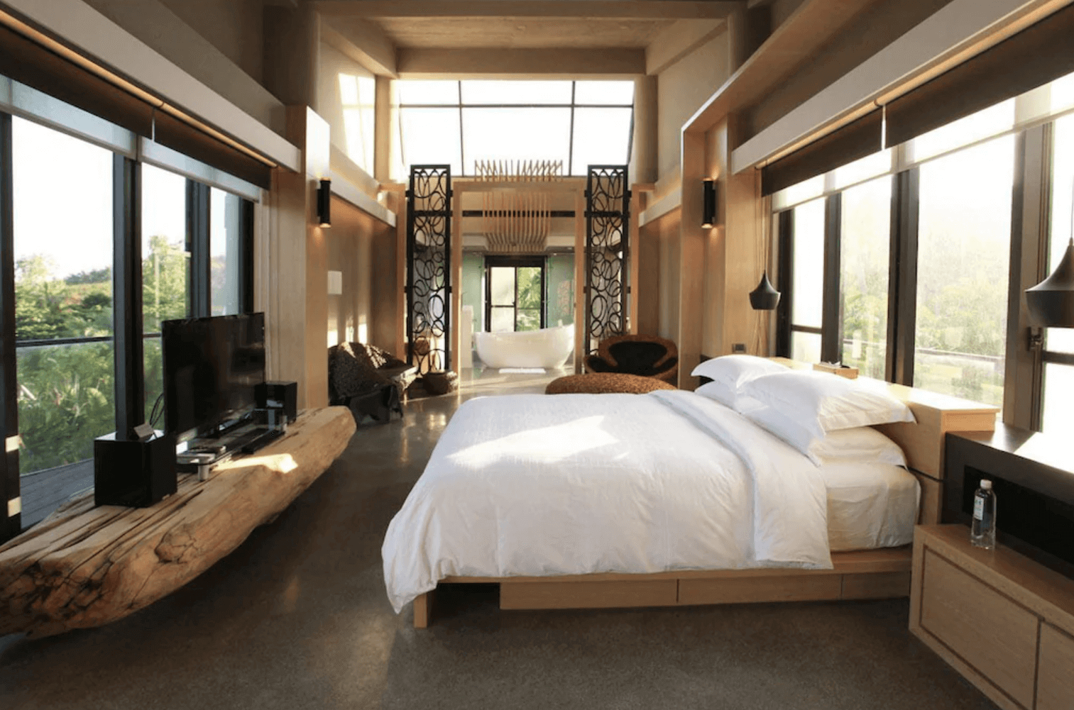 【恆春住宿】白砂15 villa 民宿質感套房，擁有大片玻璃窗與暖木裝潢，空間開闊，床邊設有自然原木電視櫃，後方為獨立浴缸與景觀衛浴區，享受絕佳隱私與美景。