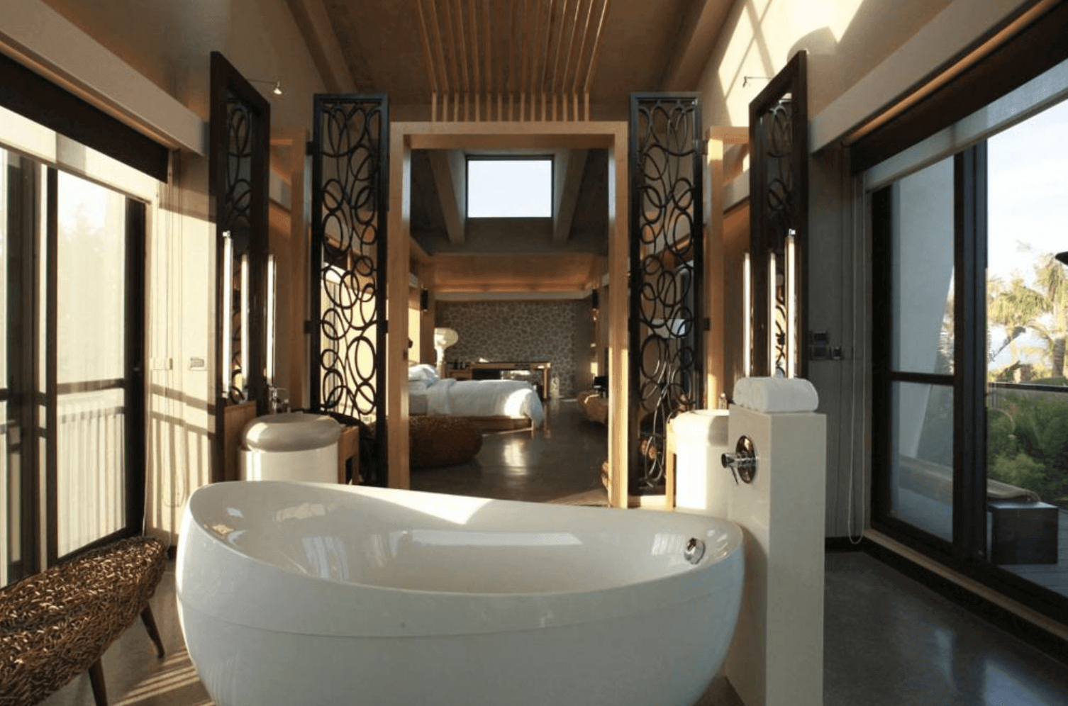 【恆春住宿】白砂15 villa 民宿浴室空間視角，設有現代圓形浴缸，面對大片窗景，空間延伸至寬敞臥房，整體設計充滿自然感與度假氛圍。