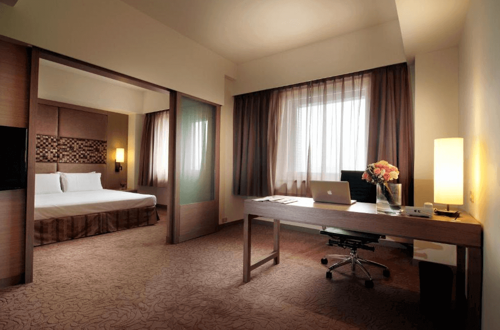 【大安住宿】福華國際文教會館商務套房 —— 寬敞的空間配置書桌與辦公椅，隔間後方為舒適雙人床房型，窗外光線灑入，適合差旅住宿。